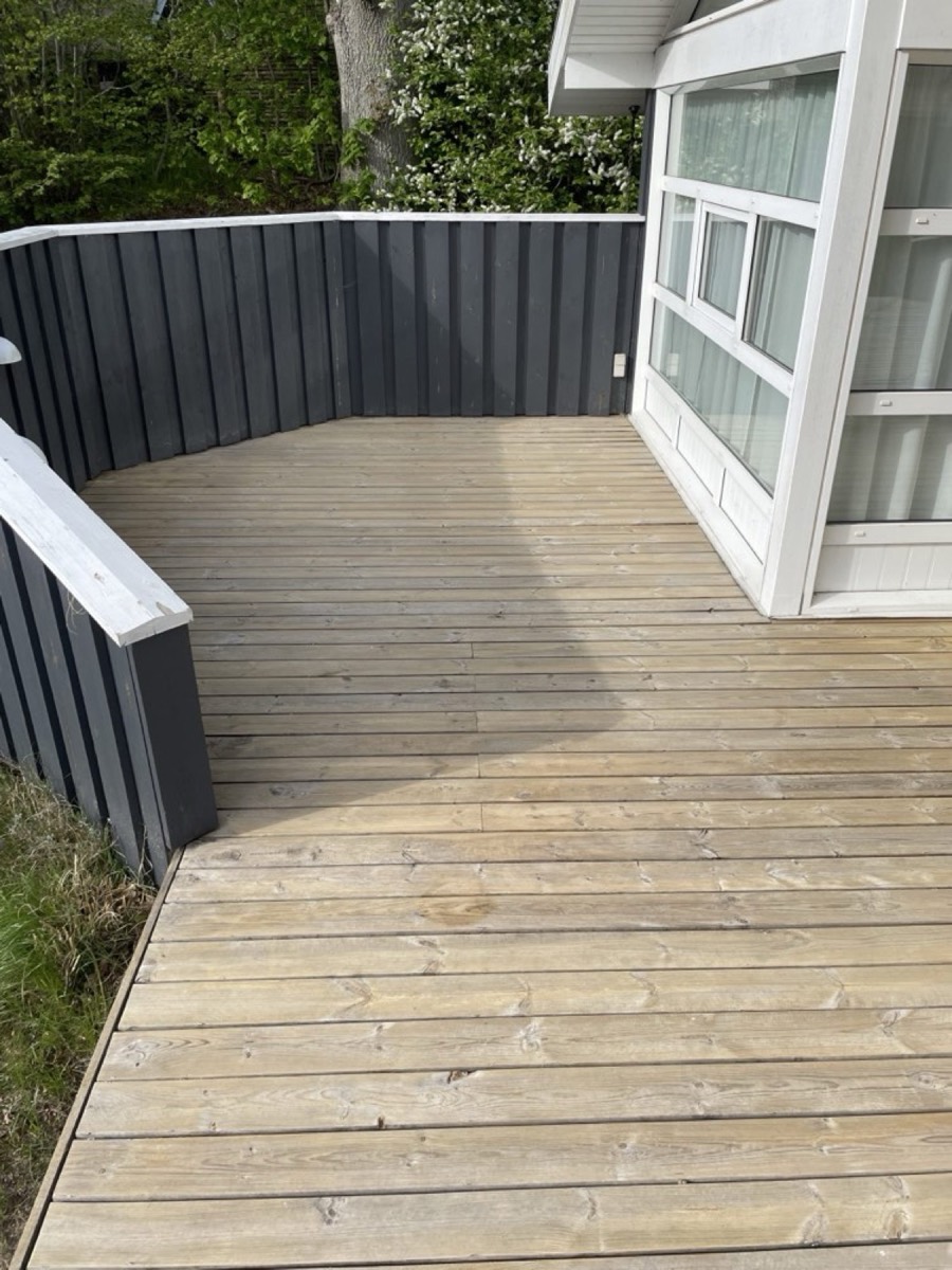 Efter: Hjørneterrasse af træ ved et sort sommerhus