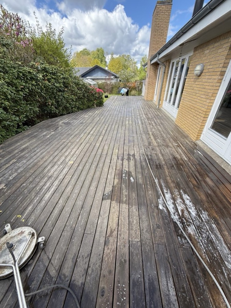 Før: Træterrasse langs et gult murstenshus