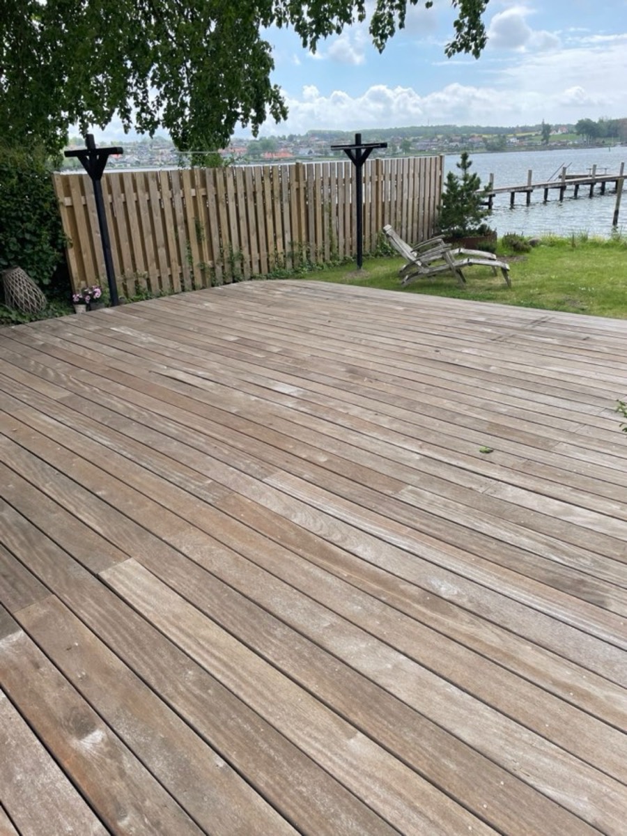 Efter: Træterrasse ved vandet med udsigt over en sø og bådebro