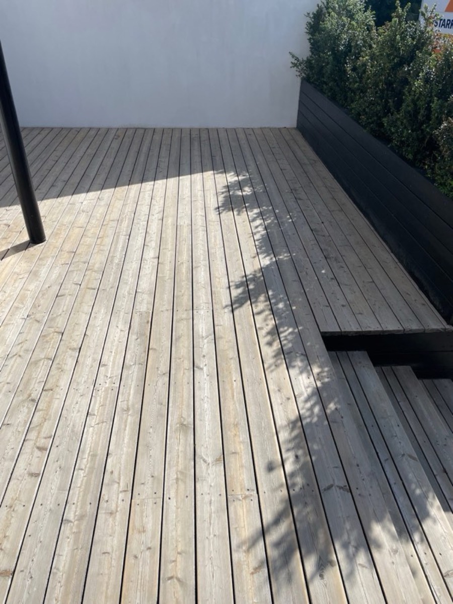 Efter: Træterrasse med trin mod en hvid mur