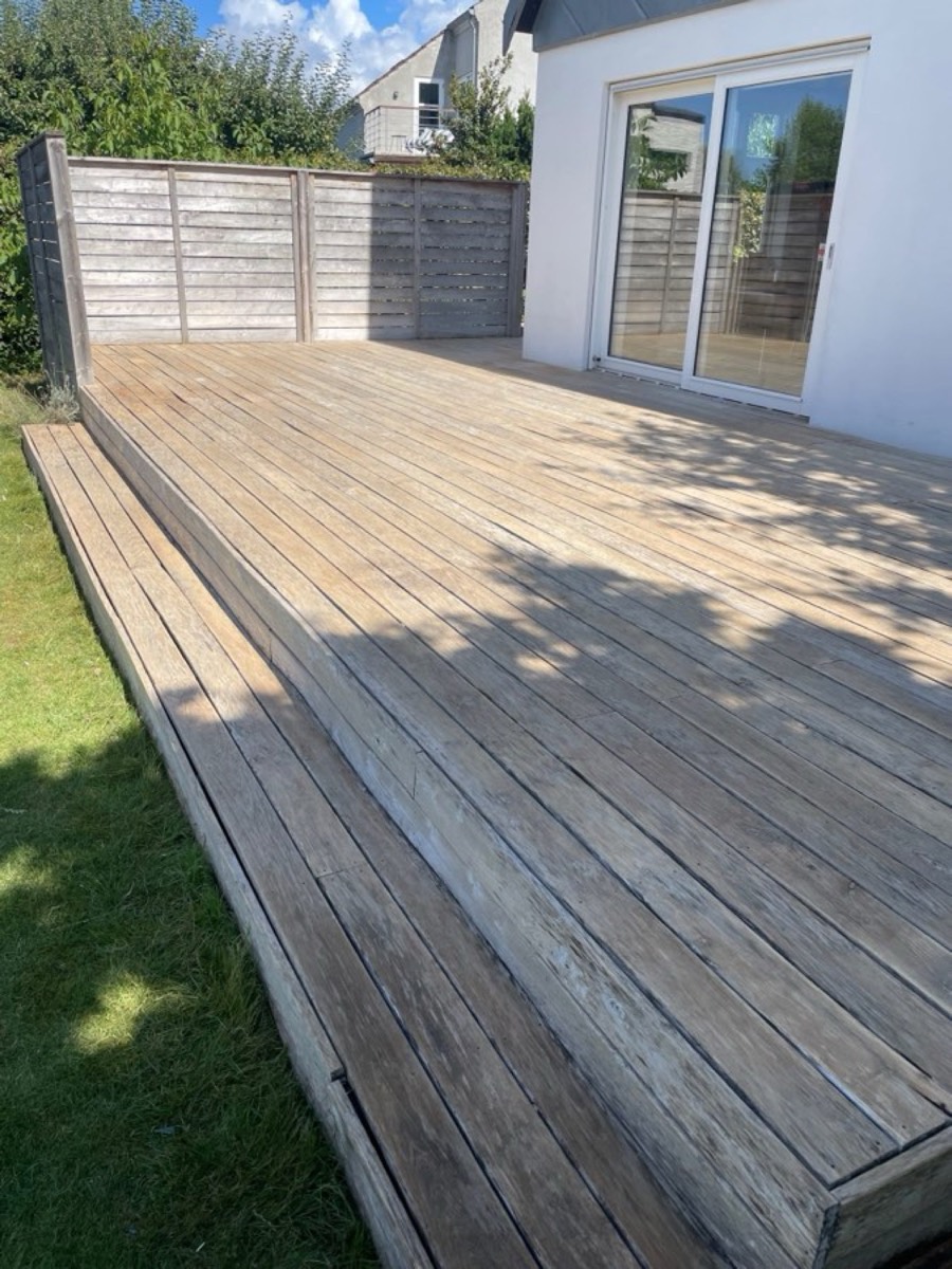 Efter: Træterrasse med plankeværk ved et hvidt hus