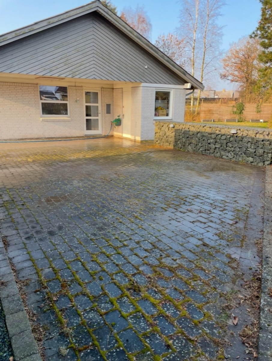 Før: Indkørsel af grå belægningssten foran en villa