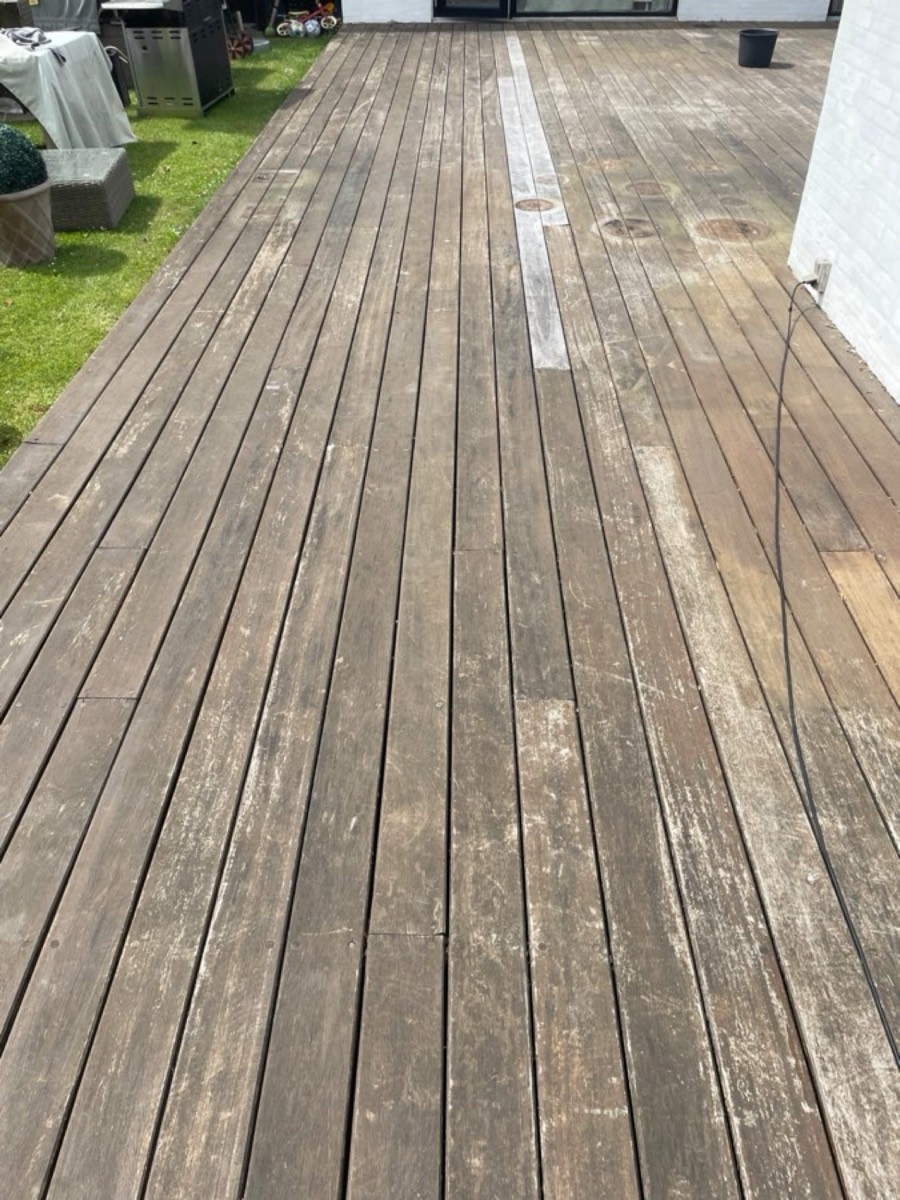 Før: Lang terrasse af hårdttræ langs et hvidt hus