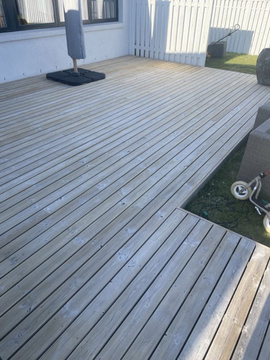 Efter: Træterrasse rundt om et sandkassehjørne ved en hvid villa