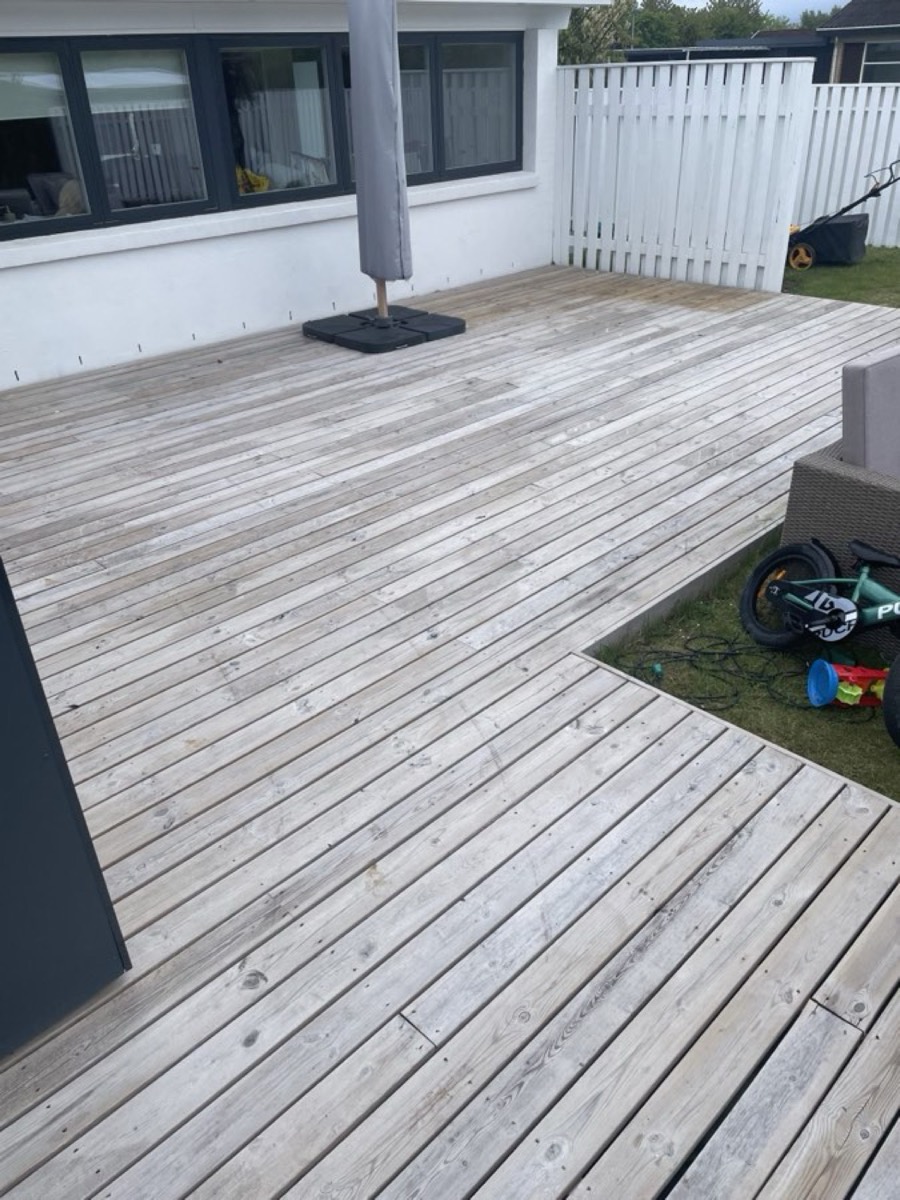 Før: Træterrasse rundt om et sandkassehjørne ved en hvid villa