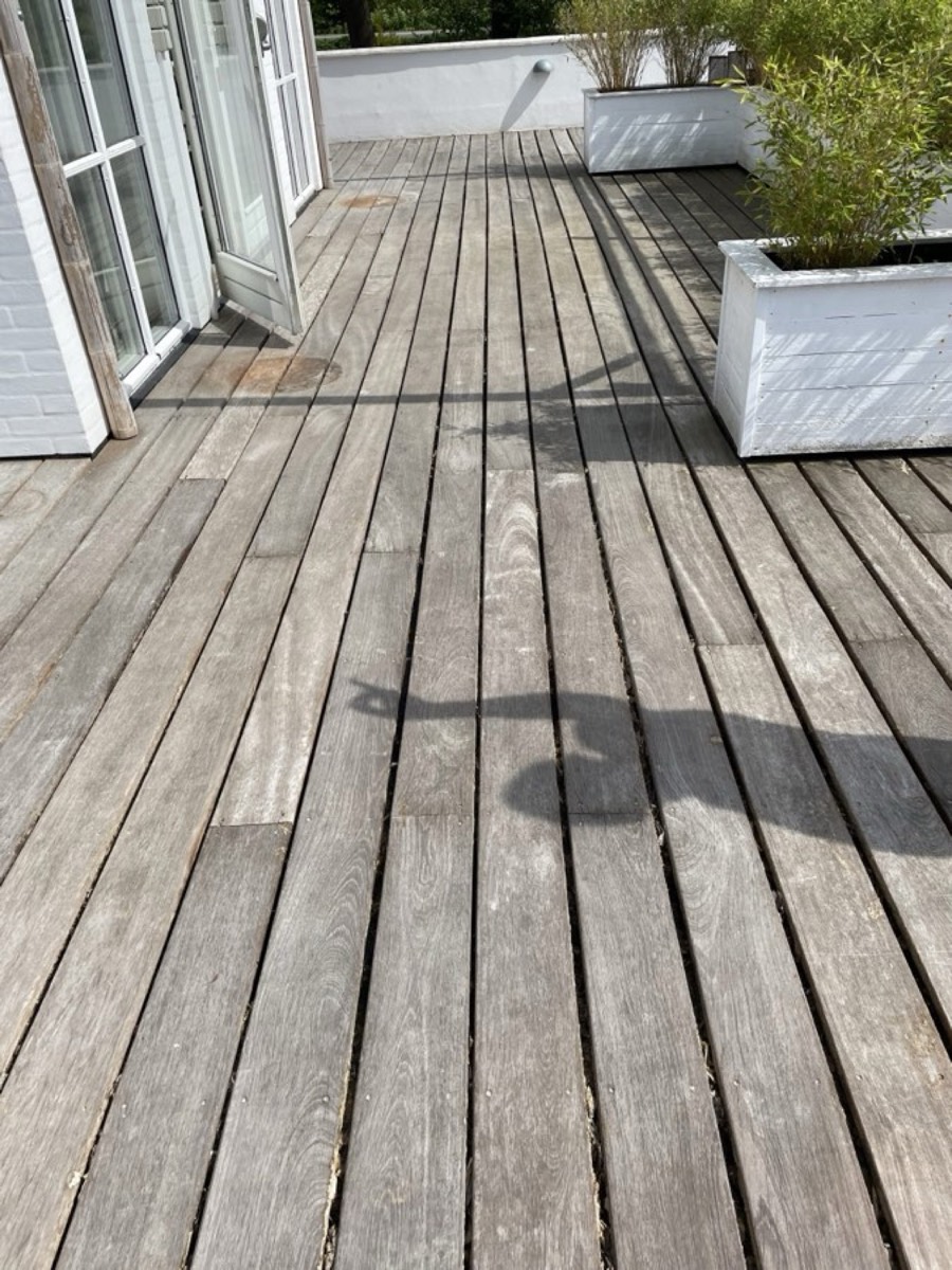 Før: Terrasse af hårdttræ med plantekasser ved en hvid villa
