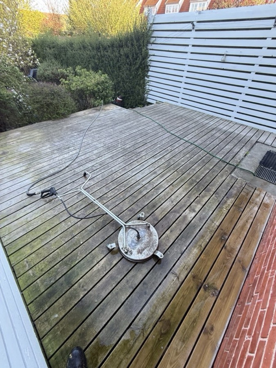 Før: Træterrasse med hvidt plankeværk ved et rødt murstenshus
